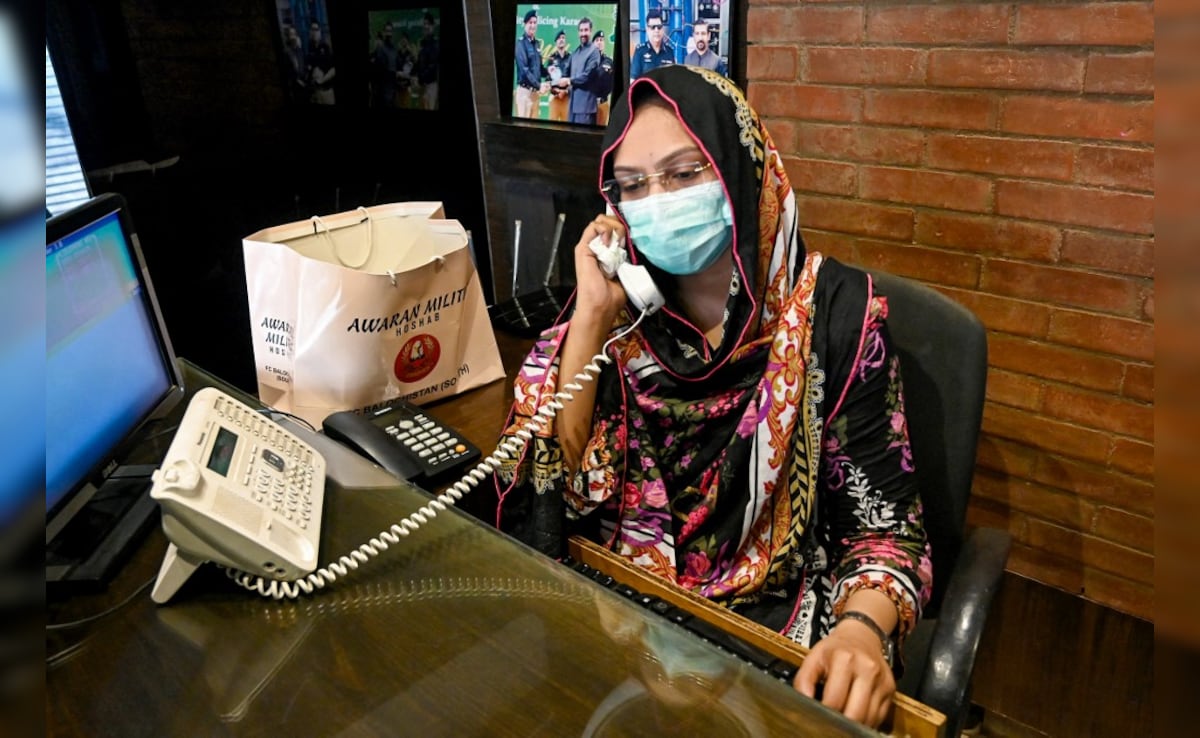 Receptionist Hina Saleem talks on a telephone at a leather factory in Karachi