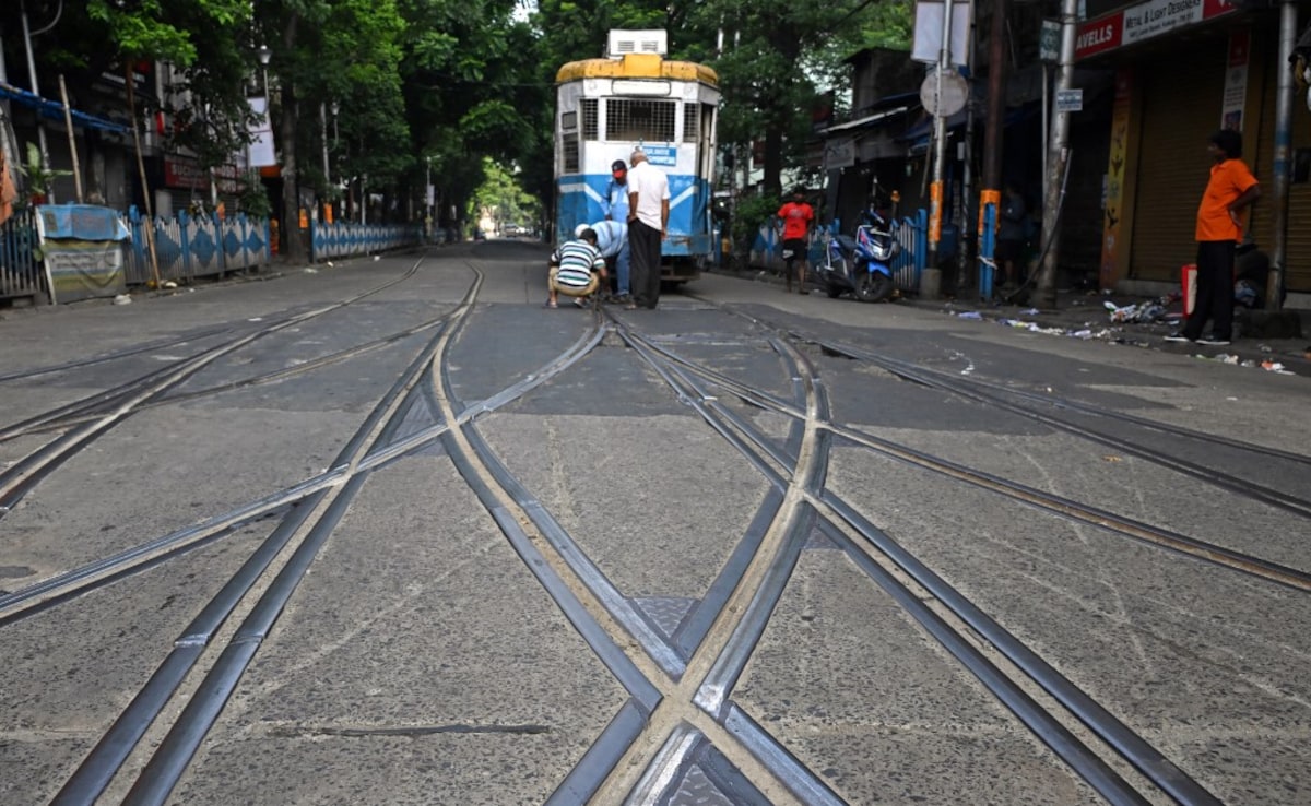 In this photo taken on September 18, 2024, tram employees manually change the track lane along a street in Kolkata