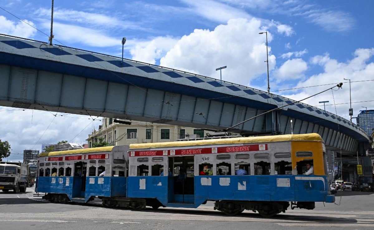 Passengers commute in a tram along a street in Kolkata